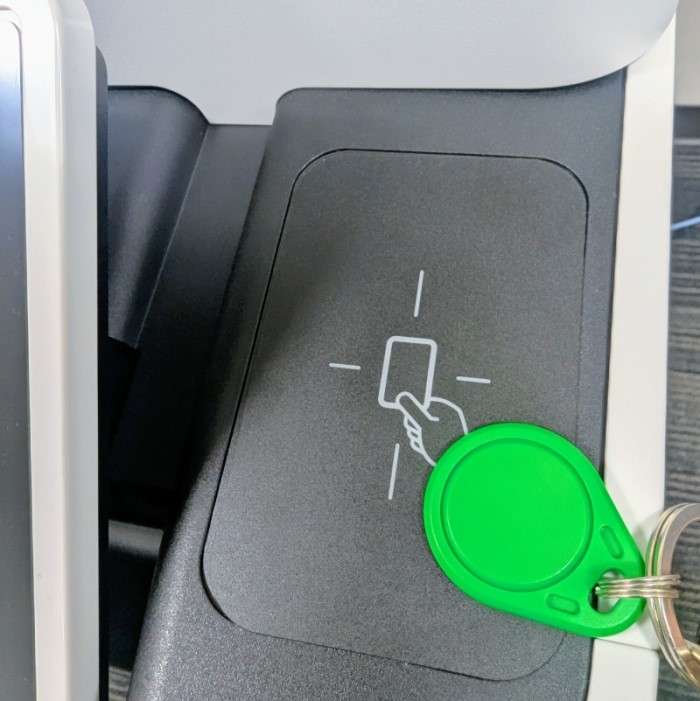Photograph of the card reader location on a Canon multi-function device with a green fob sitting on one edge